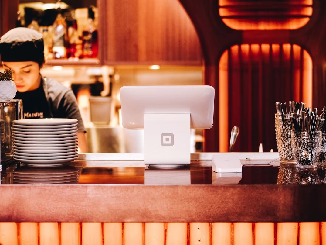 Mostrador de entrada de un restaurante con una placa NFC que invita a seguir el perfil de Instagram