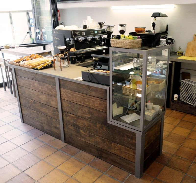 Mostrador de un café con una placa NFC y QR junto a la caja registradora