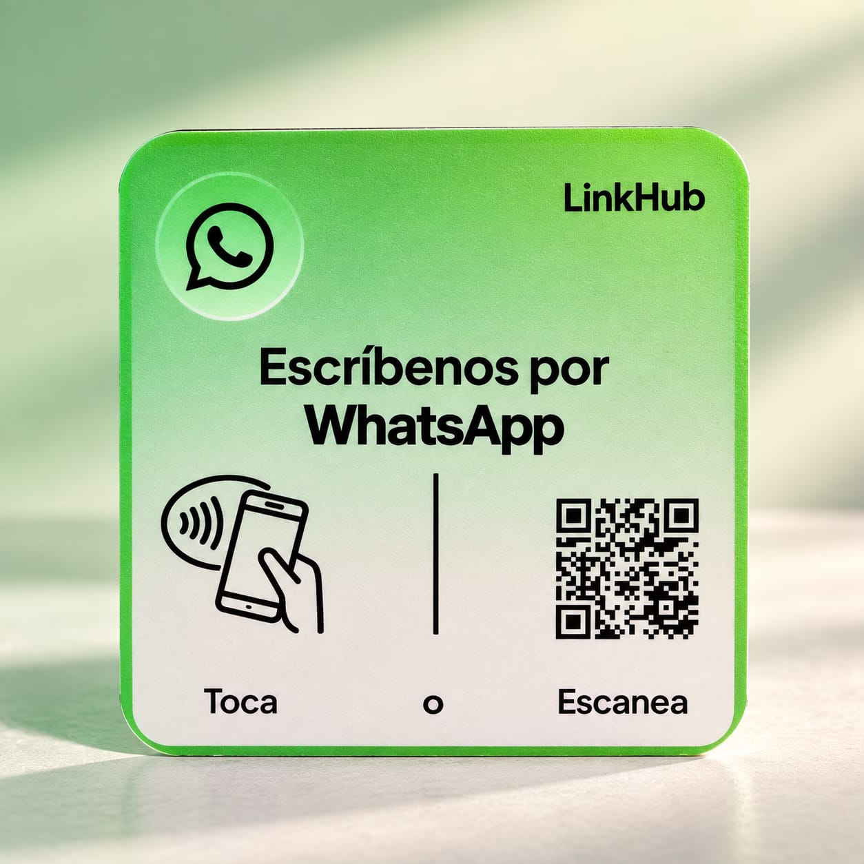 Placa mini cuadrada verde y blanca de LinkHub con el logo de WhatsApp, el texto «Escríbenos por WhatsApp», el dibujo de un celular sobre «Toca» y un código QR sobre «Escanea»