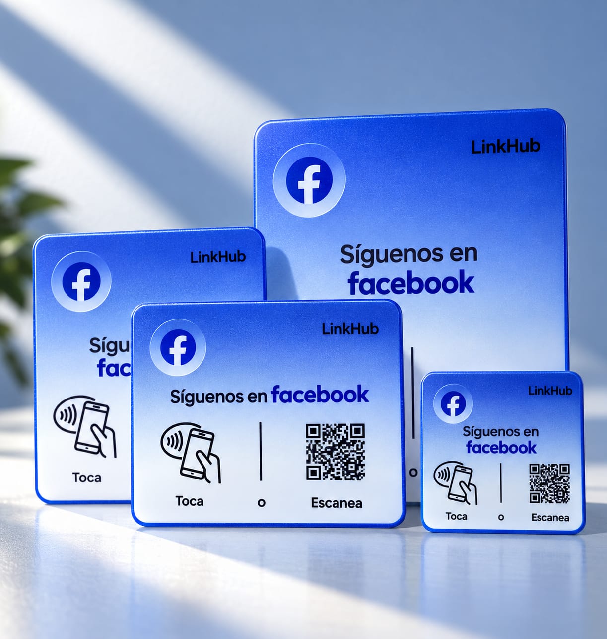 Cuatro placas azules de Facebook en los cuatro tamaños, ordenadas de mayor a menor, con la frase «Síguenos en facebook», el ícono para tocar y el código QR