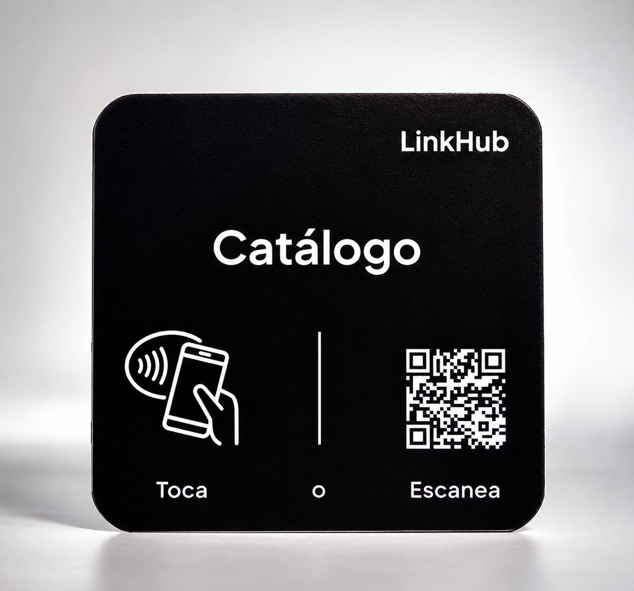 Placa mini negra de LinkHub con la palabra «Catálogo» en letras blancas, el ícono para tocar con el celular y un código QR, sobre un fondo gris claro
