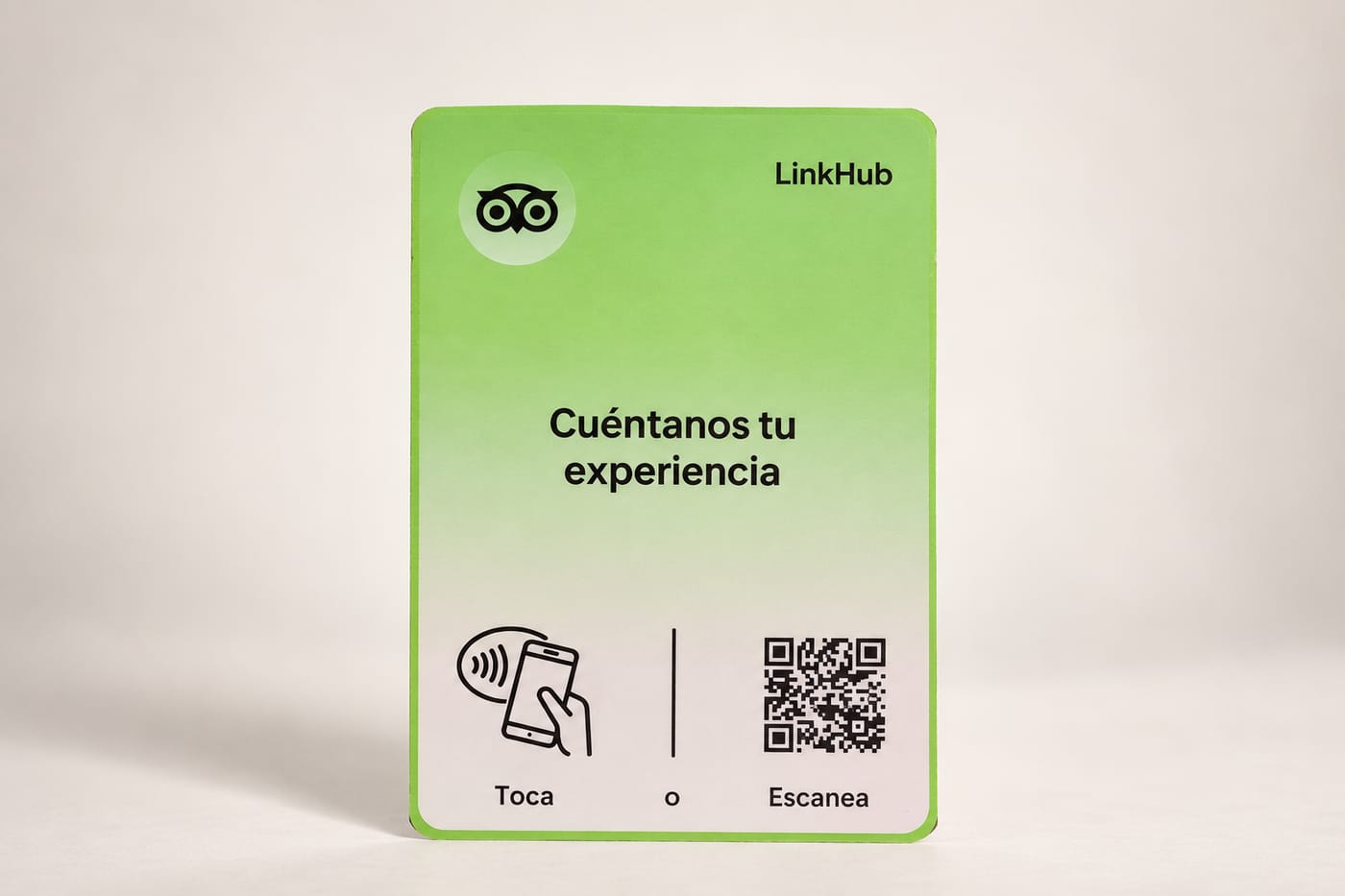 Placa de mesa de LinkHub, de 100×150 mm, con el logotipo de búho de Tripadvisor, el texto «Cuéntanos tu experiencia», el ícono para tocar con el celular y un código QR